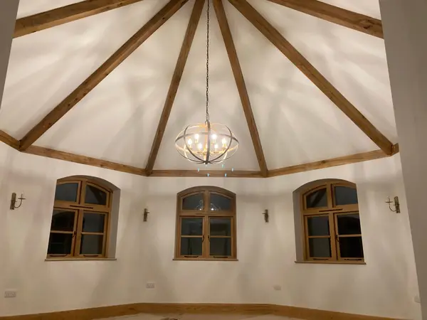 Finished vaulted room with exposed timber beams by SkimDecor Worcester